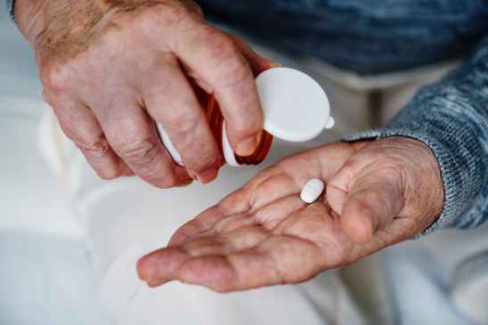 person holding white medication tablet